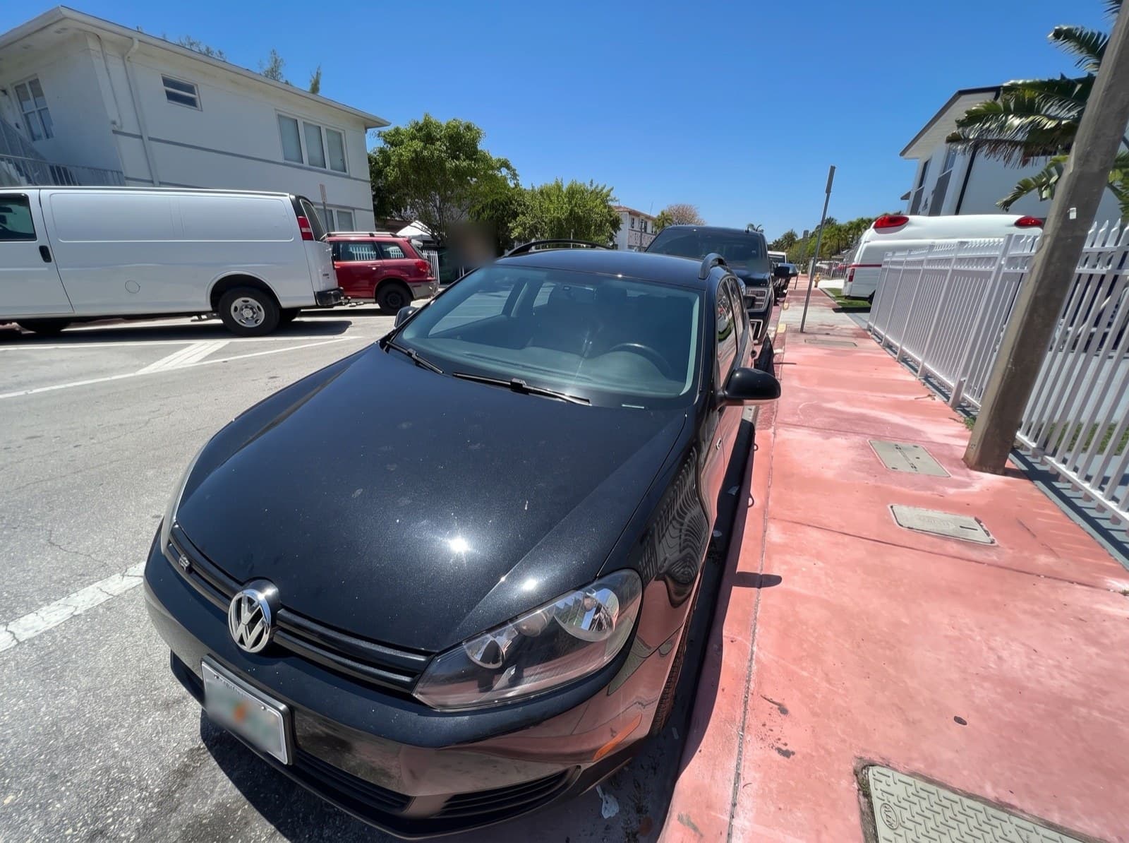 A black hatchback parked at the curb in Miami Beach, FL, after a Bang AutoGlass mobile glass job